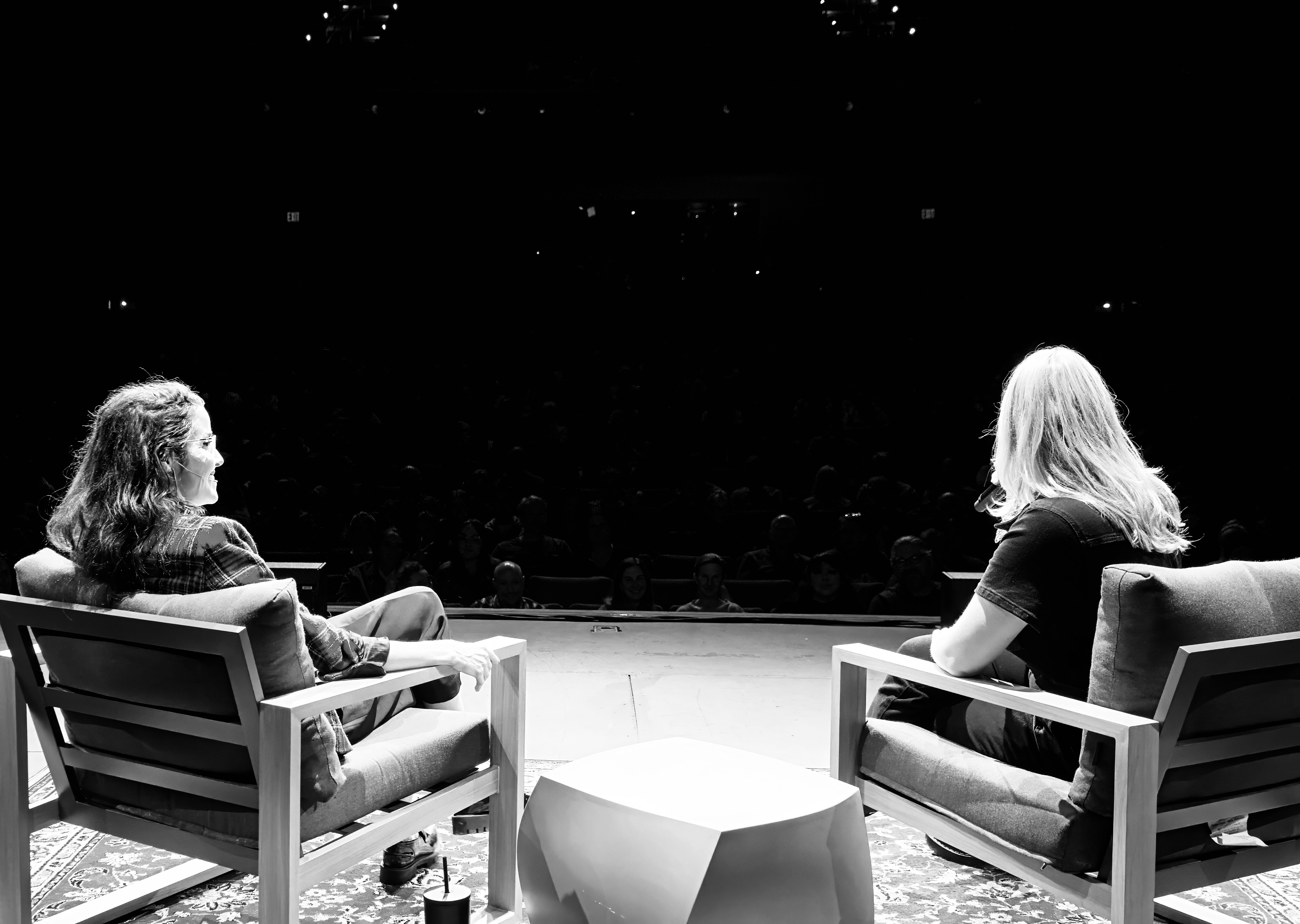 Two women on stage looking at an audience