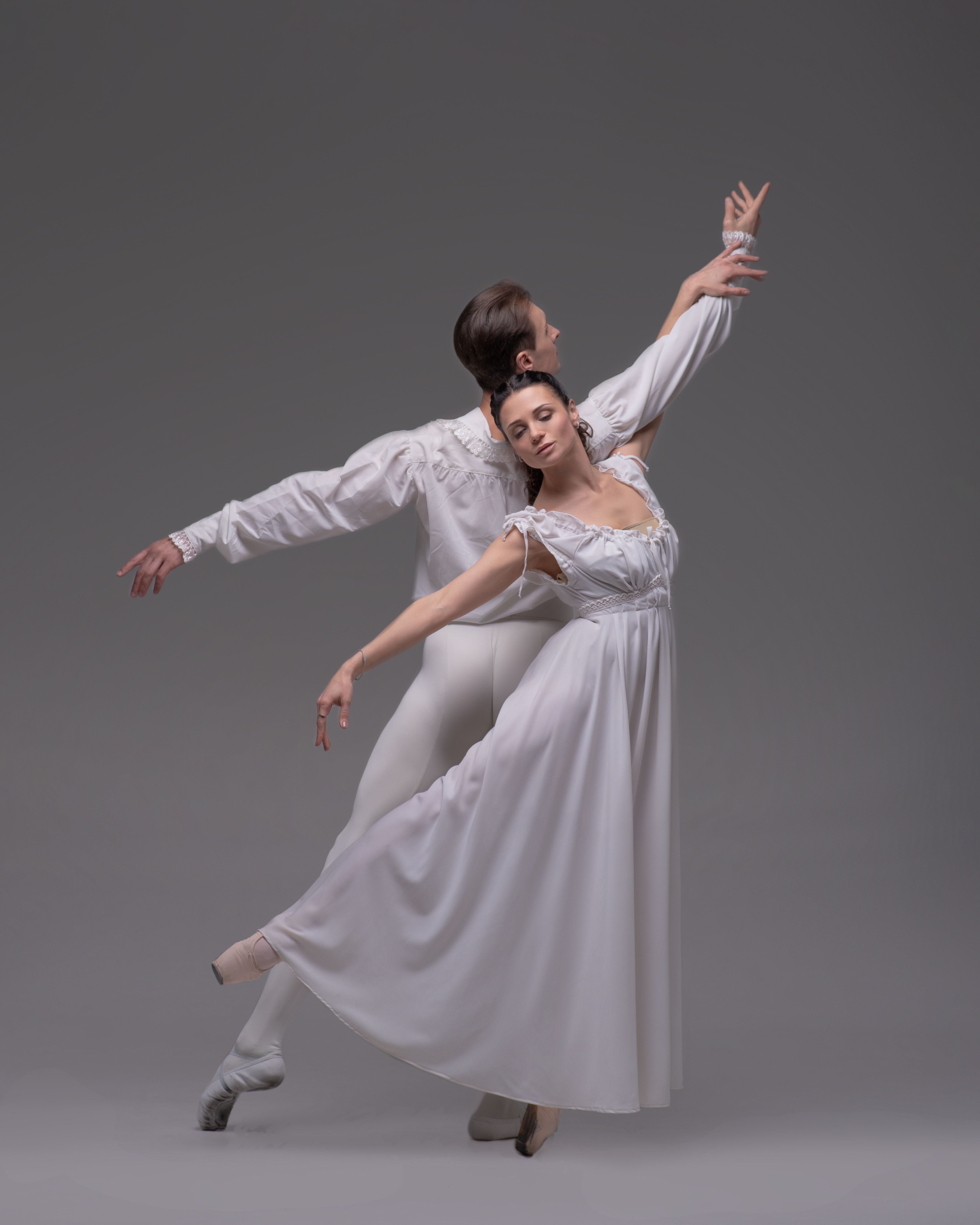 A male and female dancer both dressed in white.