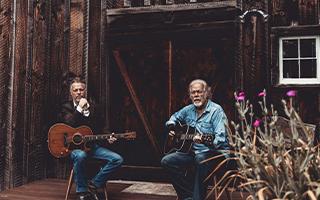 Randy & Tal Bachman seated, each with their guitar 