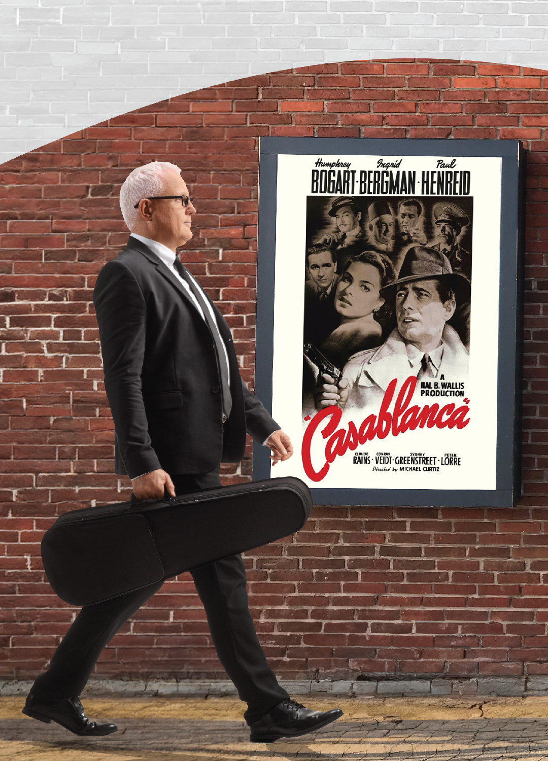 gentleman walking infront of a poster holding a violin case