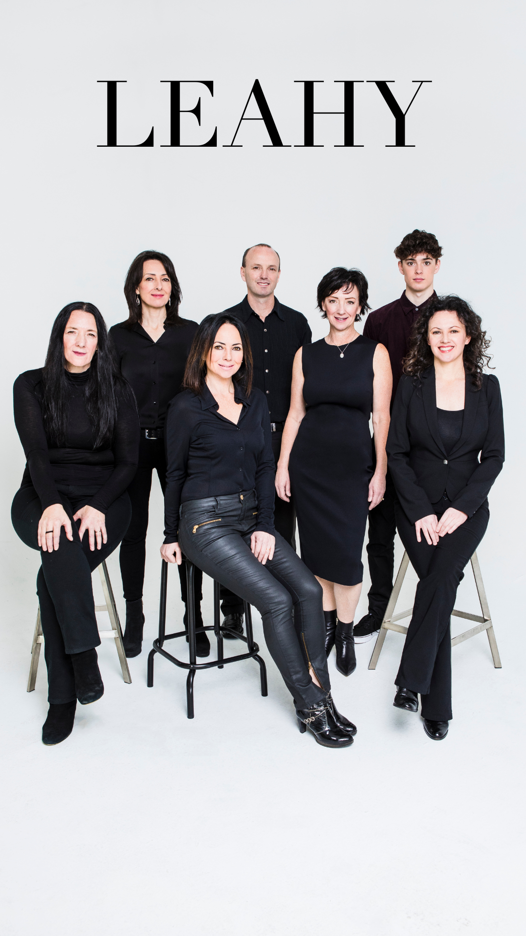 Family Leahy in all black in front of a white wall