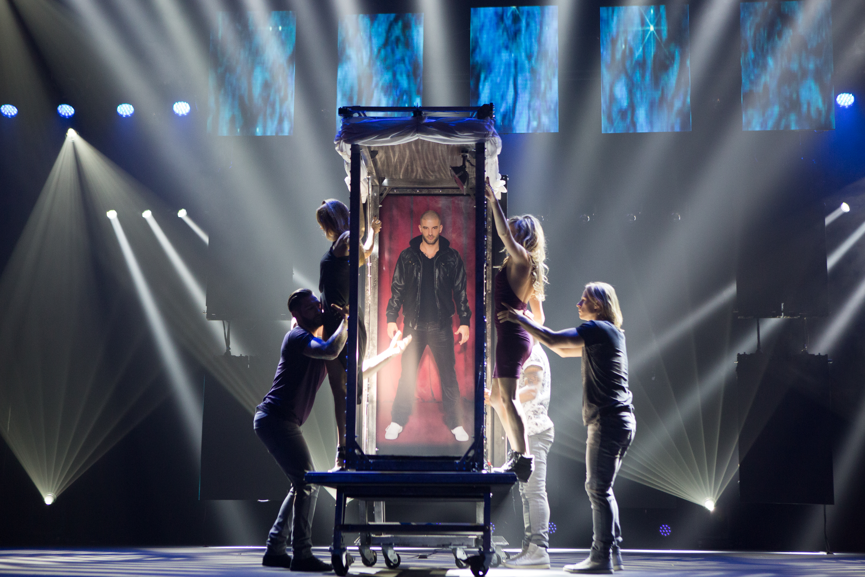 Darcy Oake in a illuminated box, on stage