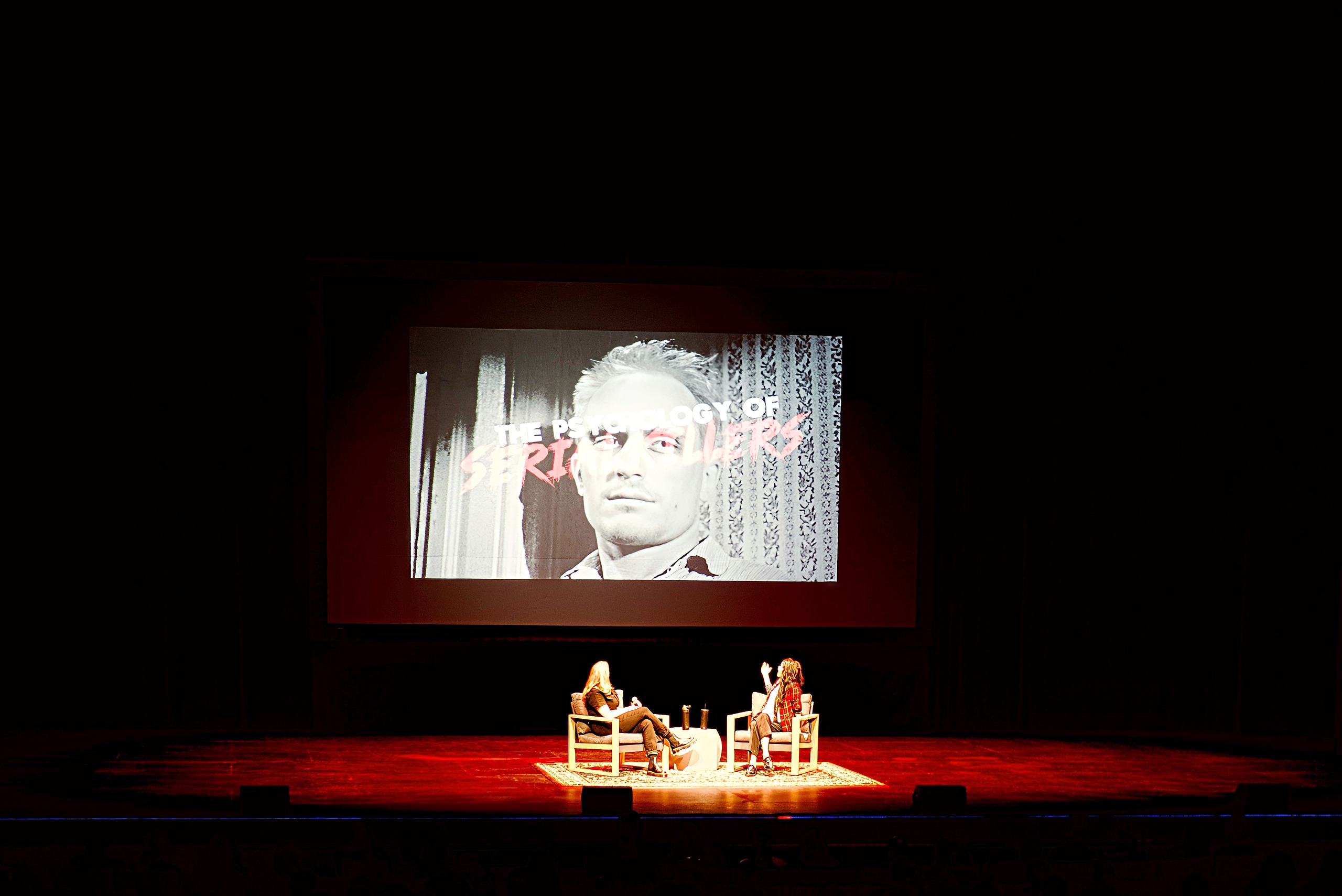 An audience view of two women on a stage