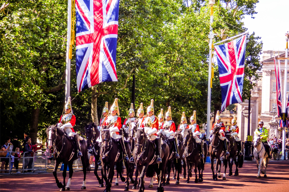 Horses and soldiers marching with British flags flying