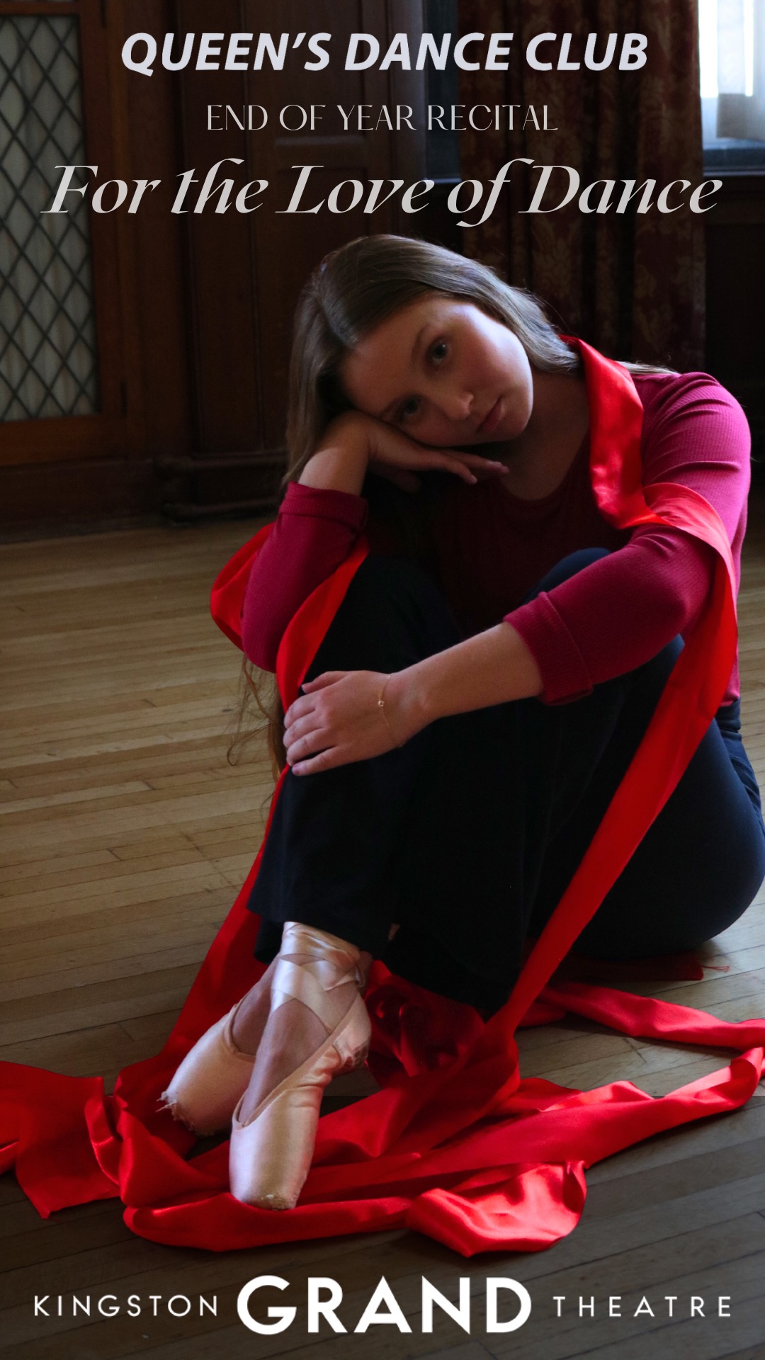 dancer dressed in red, seated on the stage with pink toe shoes