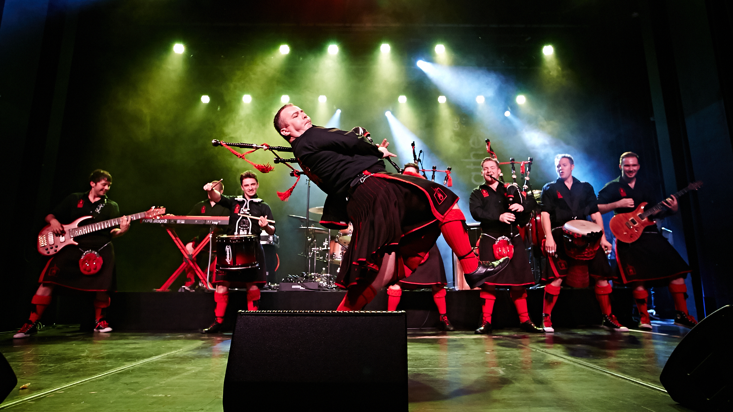 A group of bag pipe performing on a stage