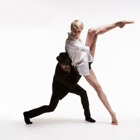 Two dancers on a white backdrop. 