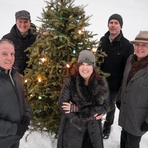 The Barra MacNeils in front of a Christmas Tree in the snow