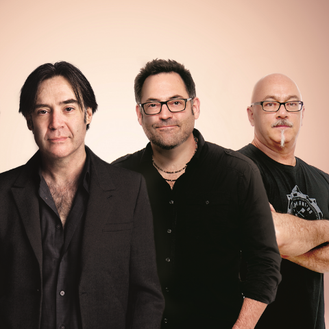 Three members posing in front of pink backdrop. 