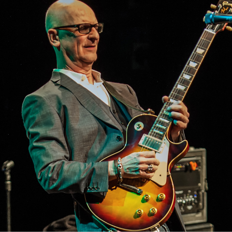 Kim Mitchell playing guitar. 