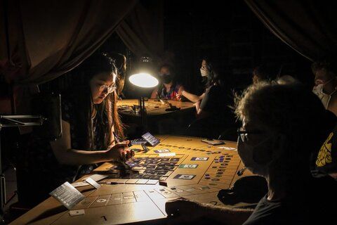 Image of a board game being played by audience members as part of a theatre presentation