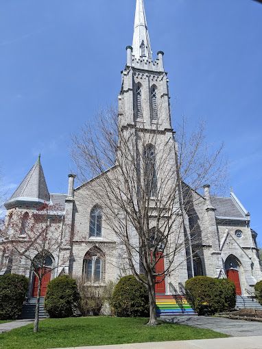 limestone church with large spire against a clear blue sky