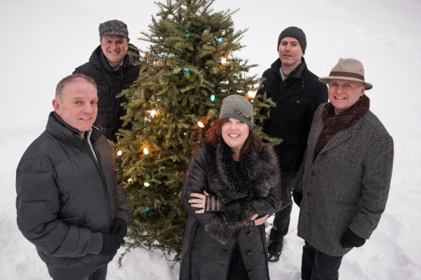 The Barra MacNeils in front of a Christmas Tree in the snow