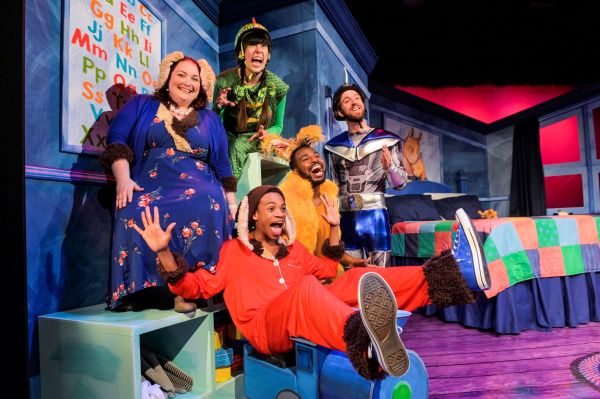 Man dressed as Llama sitting on chair with four people behind him dressed as other characters in colourful costumes