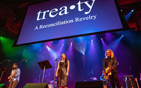 Treaty: A Reconciliation Revelry performers under a banner stating treaty