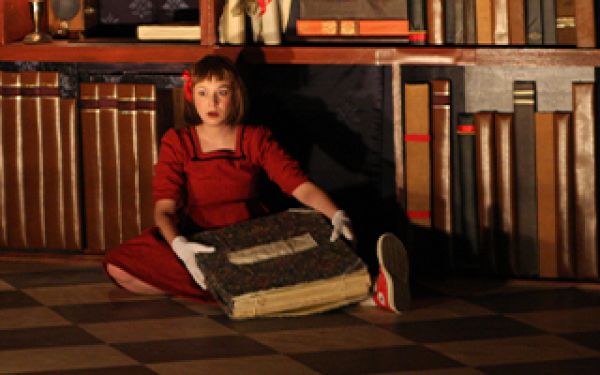 Alice sitting on the floor with a book in her lap