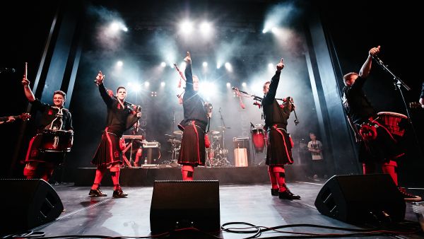 A group of bag pipe performing on a stage