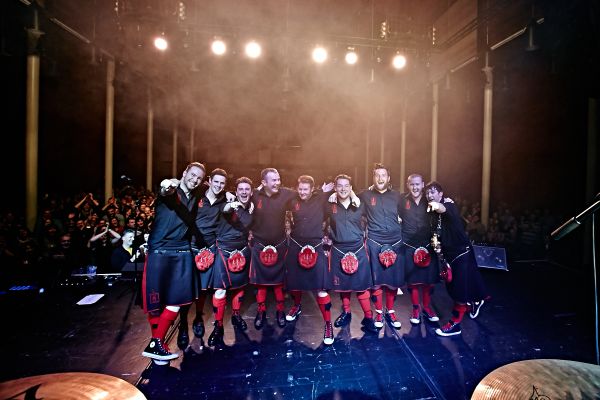 A group of bag pipe performing on a stage