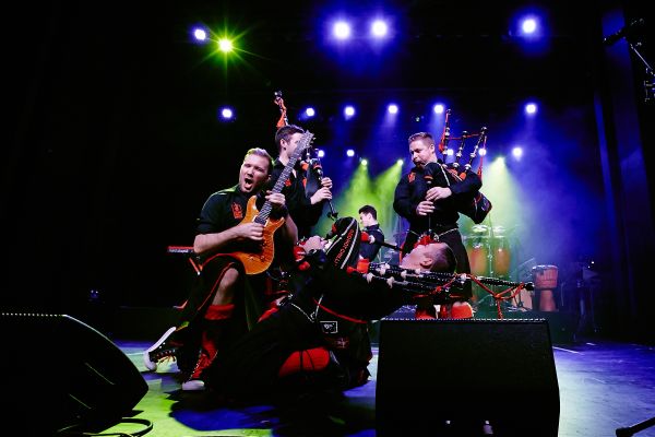 A group of bag pipe performing on a stage