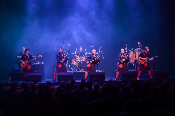 A group of bag pipe performing on a stage