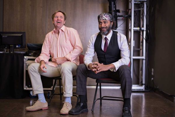 John & Waleed sitting side by side on chairs on a stage